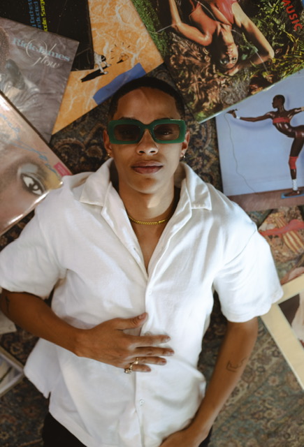 Sxdated in white shirt with green sunglasses lying on a collage